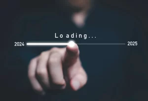 A finger pointing at a progress bar with "Loading..." and the years "2022" and "2025" as endpoints, symbolizing anticipation for the new year.