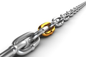 A silver chrome chain with one gold link, against a white background.